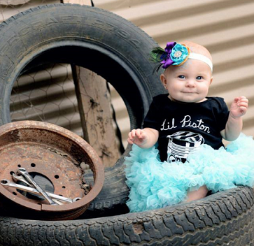 Baby in Lil Piston Shirt near tires